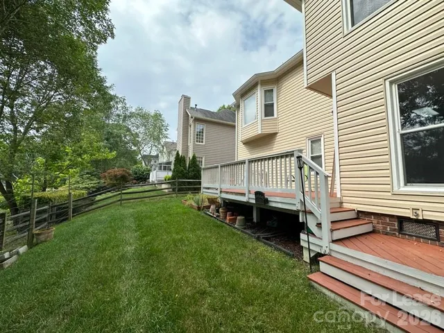 a backyard of a house with barbeque oven table and chairs