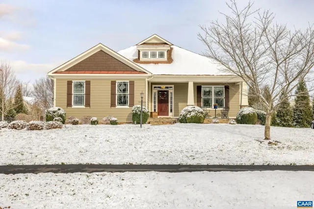 a front view of a house with a yard covered in snow