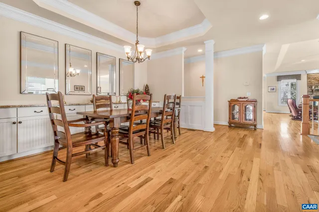 a dining room with furniture a chandelier and wooden floor