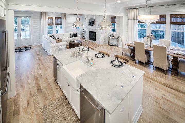 77 Shore Bridge Cir Inlet Beach Inlet Beach, FL 32461 - Photo 7 of 20 a white table sitting next to a white kitchen with granite countertop a stove a sink a dining table and chairs