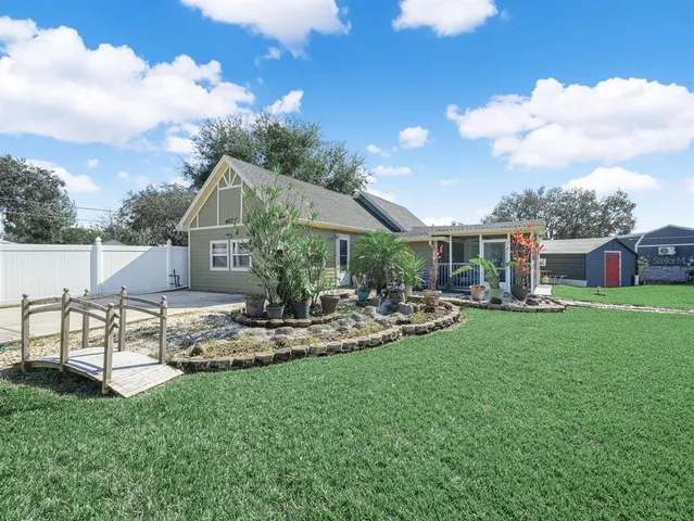 a view of a house with backyard and sitting area