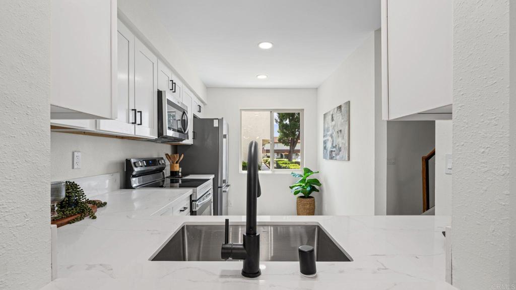 134 Espanas Escondido, CA 92026 - Photo 6 of 33 a kitchen with stainless steel appliances kitchen island granite countertop a refrigerator and a sink