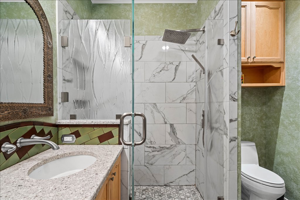 37 Pillow Road Austin, TX 78745 - Photo 11 of 18 Granite counters and a rainfall shower head create a soothing bathing experience.