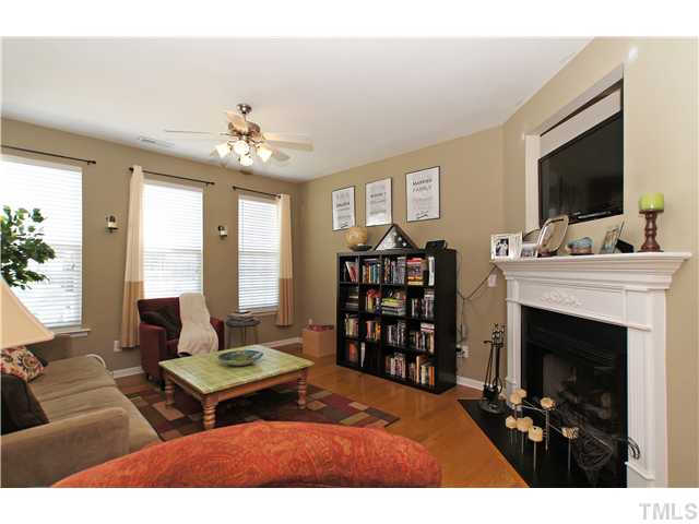 7721 Winners Edge Street Raleigh, NC 27617 - Photo 3 of 20 a living room with furniture a flat screen tv and a fireplace