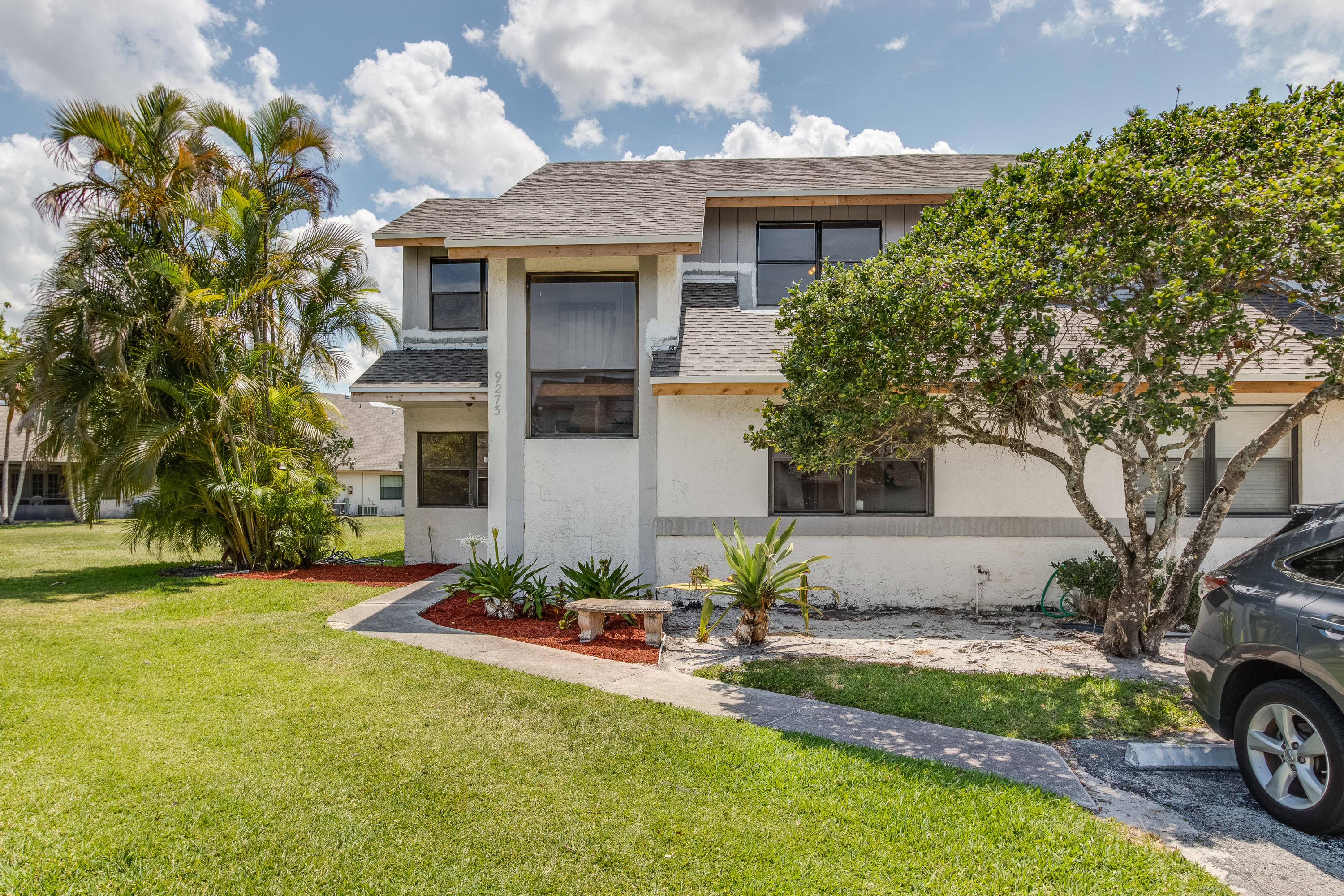 9273 Ketay Circle Boca Raton, FL 33428 - Photo 26 of 27 a front view of a house with a garden and trees