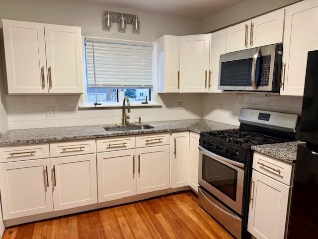 609 King Philip Street Fall River, MA 02724 - Photo 2 of 14 a kitchen with granite countertop a stove top oven microwave and cabinets