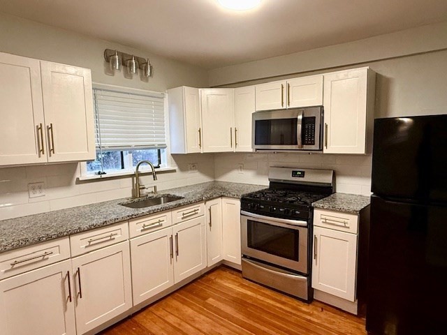 609 King Philip Street Fall River, MA 02724 - Photo 10 of 14 a kitchen with granite countertop a stove a sink and a microwave