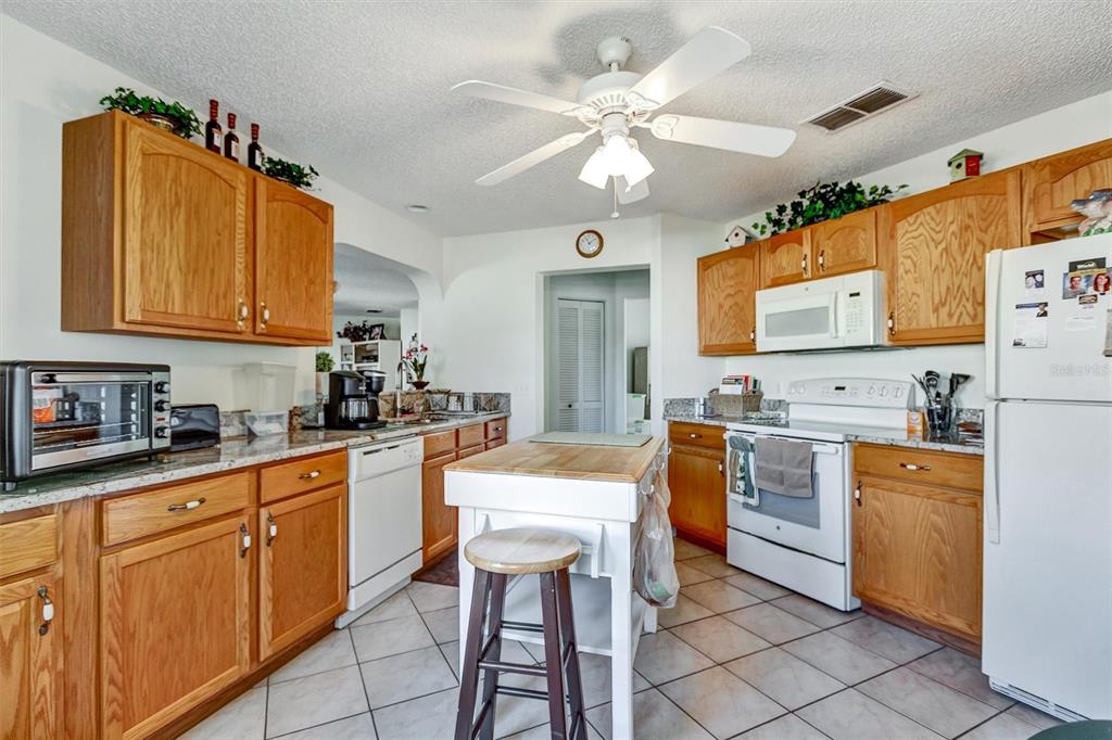 9485 Southwest 92nd Street Road Ocala, FL 34481 - Photo 12 of 38 a kitchen with stainless steel appliances granite countertop a sink a stove cabinets dining table and chairs