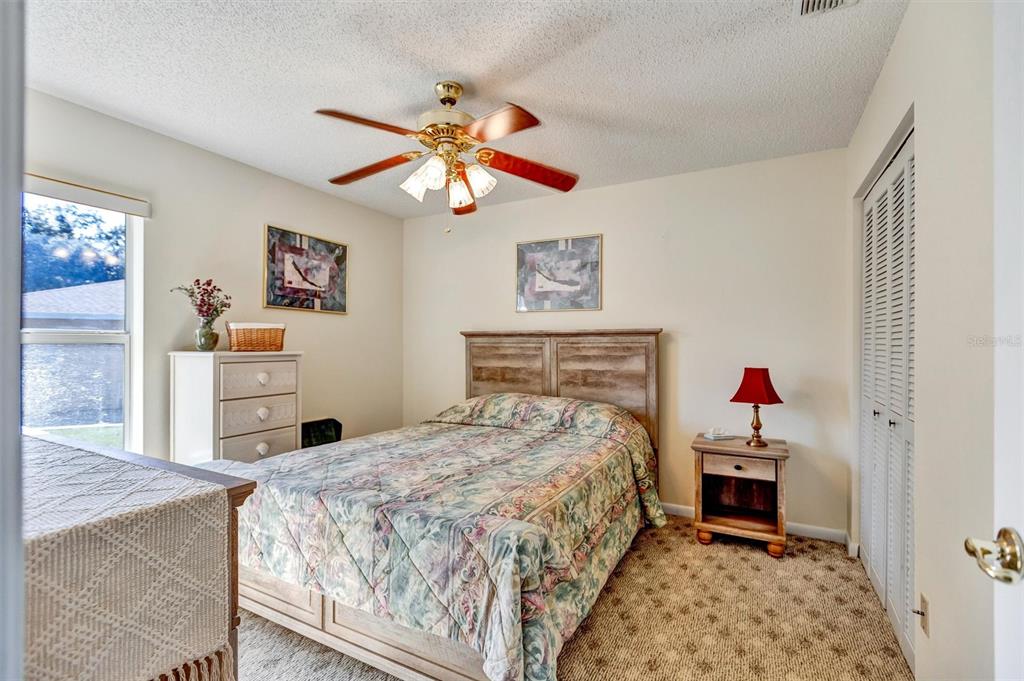 9485 Southwest 92nd Street Road Ocala, FL 34481 - Photo 18 of 38 a bedroom with a bed and a chandelier