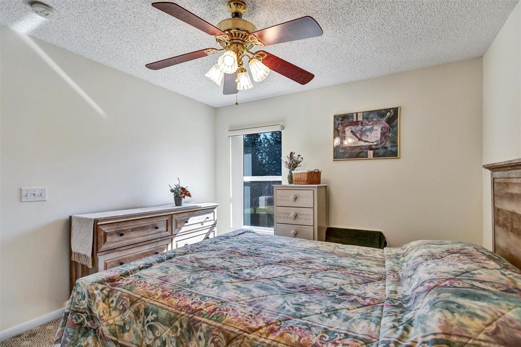 9485 Southwest 92nd Street Road Ocala, FL 34481 - Photo 21 of 38 a bedroom with a bed and a chandelier