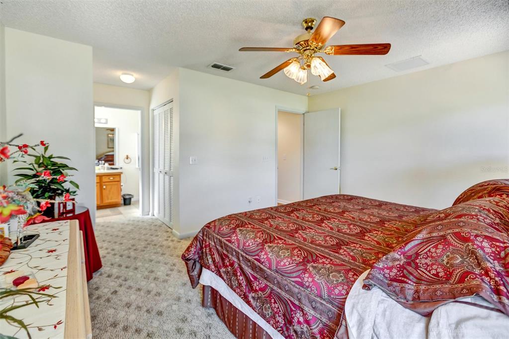 9485 Southwest 92nd Street Road Ocala, FL 34481 - Photo 27 of 38 a bedroom with a bed and a chandelier