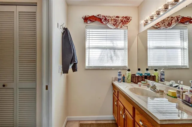 a bathroom with a granite countertop sink and a window