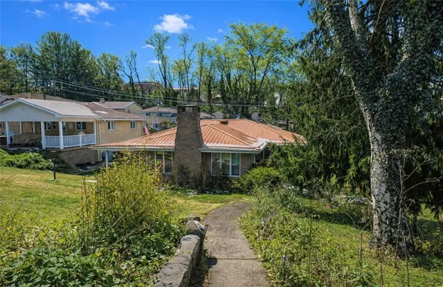 a view of a house with a yard and potted plants
