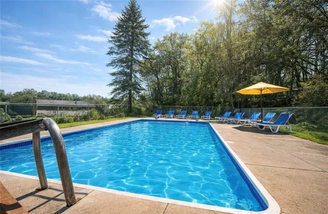 a view of a swimming pool with a table and chairs under an umbrella