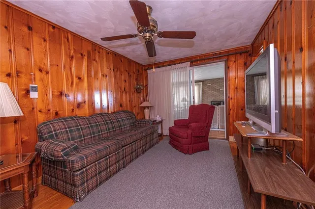 a living room with furniture a ceiling fan and a window