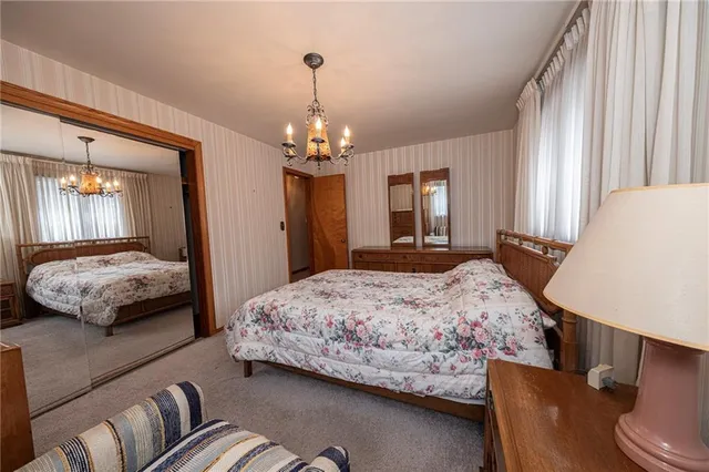 a bedroom with a large bed and a chandelier