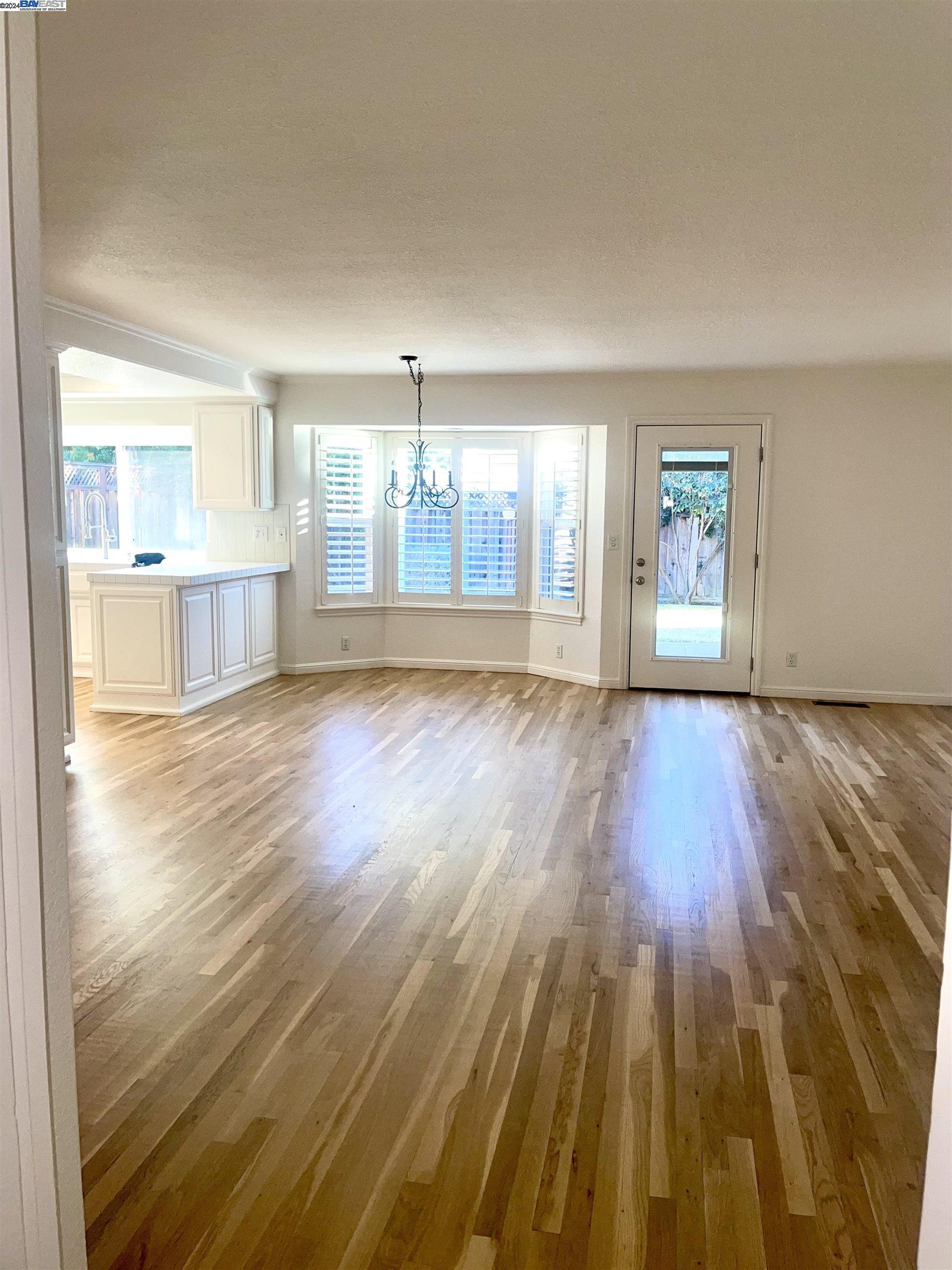1361 Hudson Way Livermore, CA 94550 - Photo 8 of 23 an empty room with wooden floor and windows