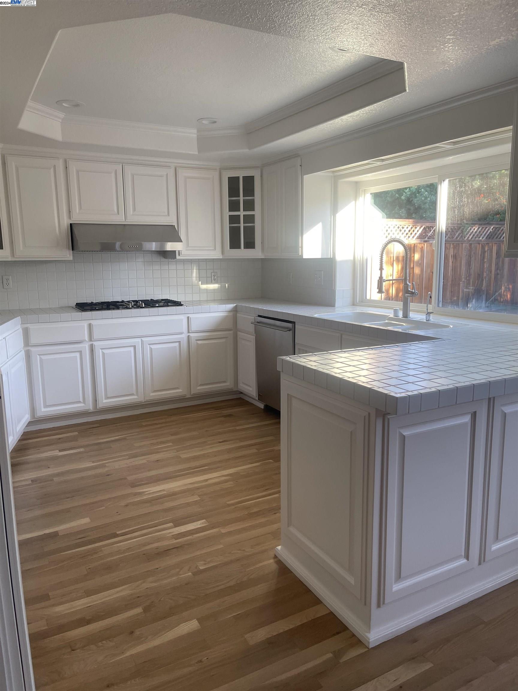 1361 Hudson Way Livermore, CA 94550 - Photo 9 of 23 a kitchen with kitchen island granite countertop a sink cabinets and wooden floor