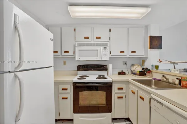 a kitchen with white cabinets and white appliances