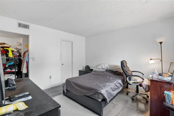 a bedroom with a bed and a computer on a desk