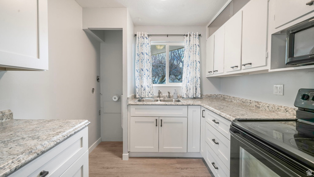 359 East 8400th Street South Sandy, UT 84070 - Photo 6 of 35 Kitchen with black appliances, white cabinets, and light wood-style flooring