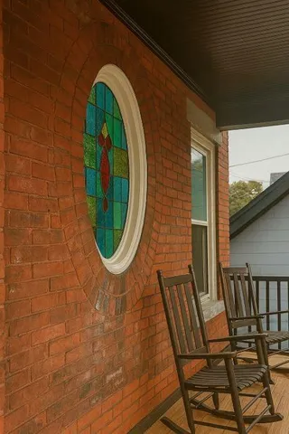 an empty room with wooden floor fireplace and windows