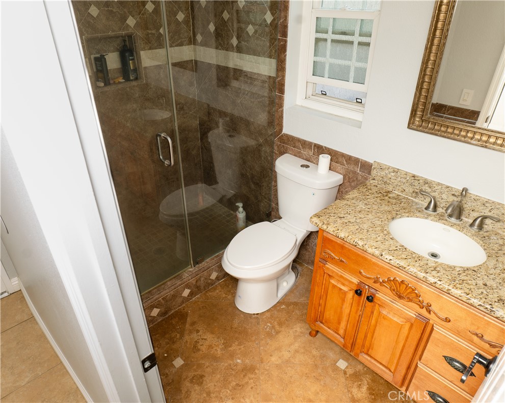 2831 Carma Court Riverside, CA 92503 - Photo 9 of 20 a bathroom with a granite countertop toilet sink and a shower