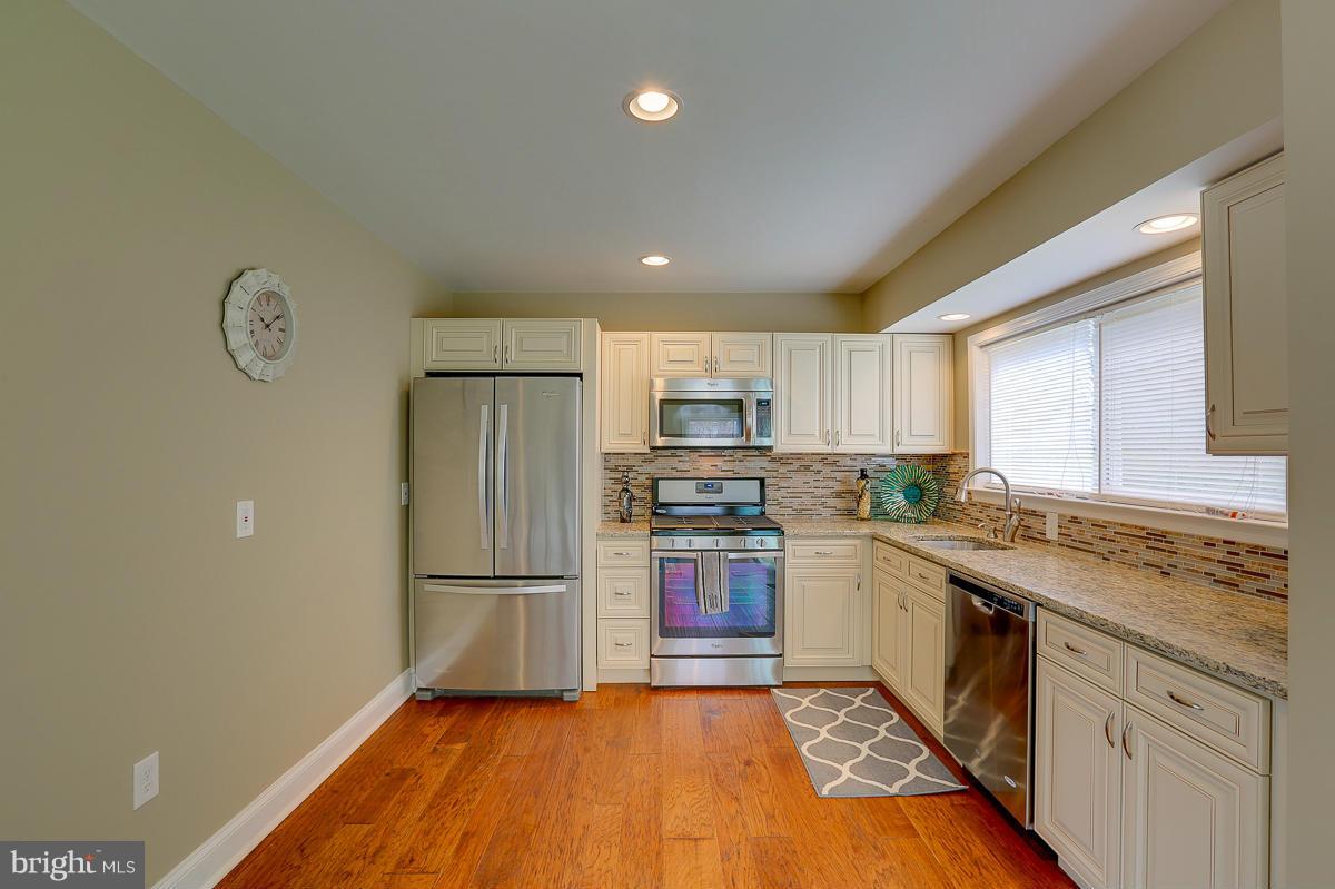 144 Embleton Road Owings Mills, MD 21117 - Photo 4 of 26 a kitchen with stainless steel appliances granite countertop a refrigerator and a stove top oven