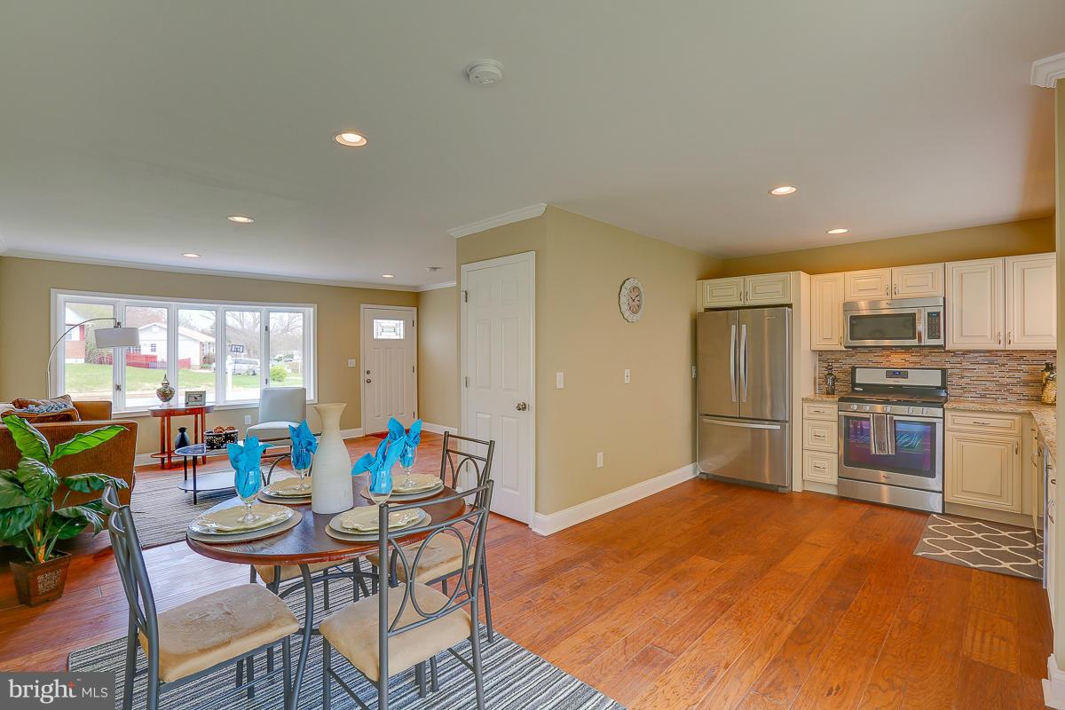 144 Embleton Road Owings Mills, MD 21117 - Photo 6 of 26 a living room with stainless steel appliances kitchen island granite countertop furniture and a dining table with kitchen view