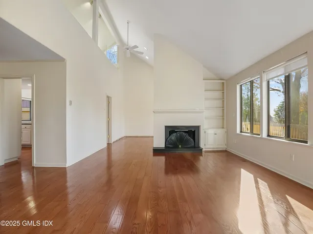 a view of empty room with wooden floor and fireplace