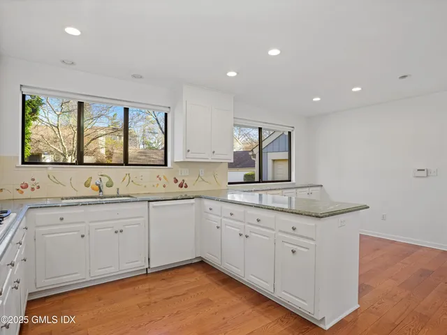 a large kitchen with stainless steel appliances granite countertop a stove a sink and a refrigerator