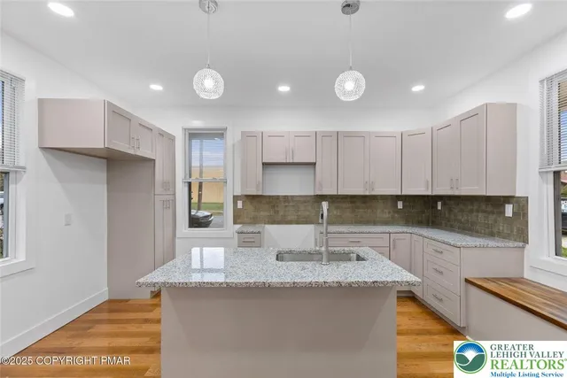 a kitchen with kitchen island granite countertop a sink and refrigerator