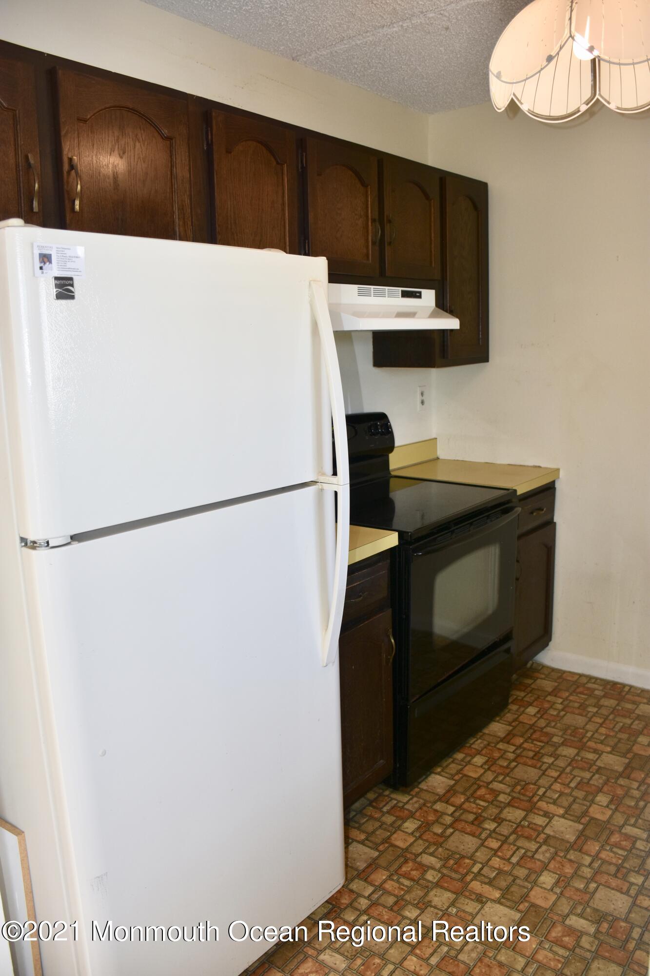 1000 River Road, Unit 3J Belmar, NJ 07719 - Photo 4 of 19 a kitchen with a refrigerator and a stove