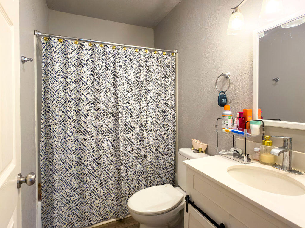 1908 47th Street Lubbock, TX 79412 - Photo 11 of 21 a bathroom with a sink a toilet and a mirror