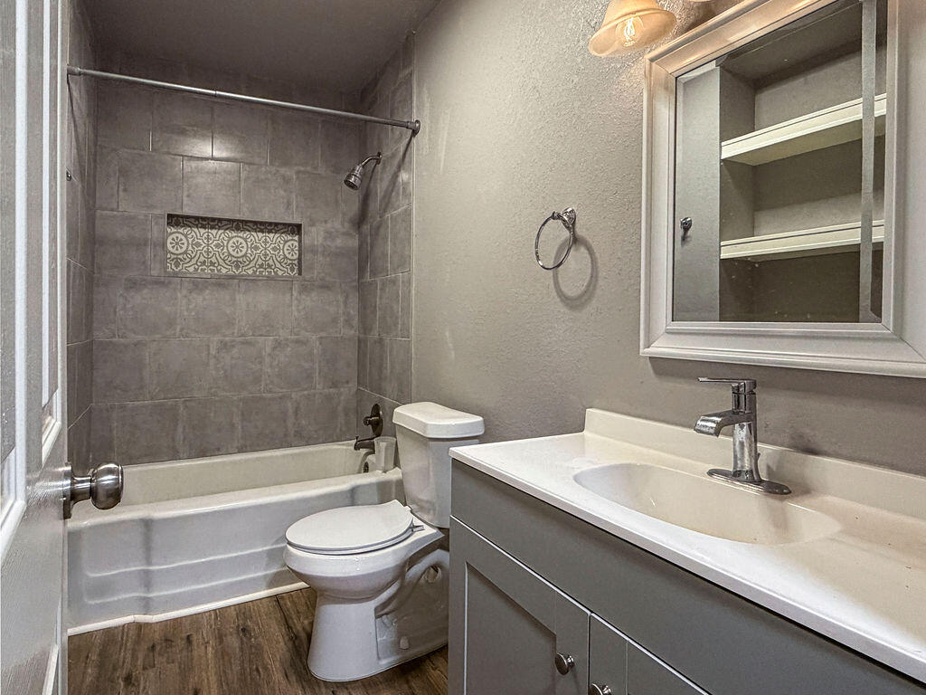 1908 47th Street Lubbock, TX 79412 - Photo 15 of 21 a bathroom with a sink a toilet and a mirror
