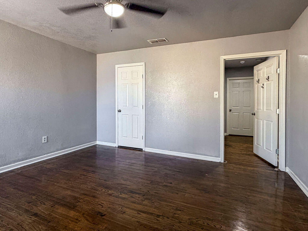 1908 47th Street Lubbock, TX 79412 - Photo 17 of 21 a view of an empty room with wooden floor and a ceiling fan