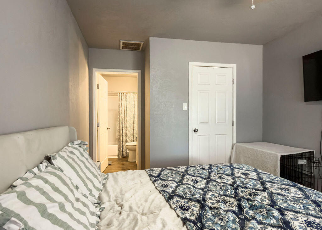 1908 47th Street Lubbock, TX 79412 - Photo 10 of 21 a bedroom with a bed and a flat tv screen on dresser