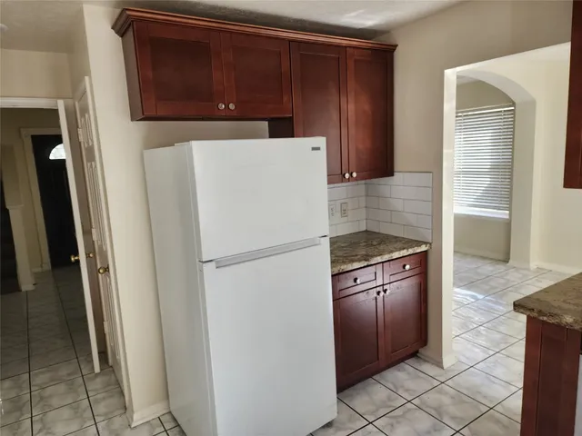 a white refrigerator freezer and a stove sitting inside of a kitchen
