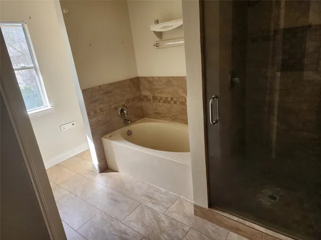 a bathroom with a tub and shower