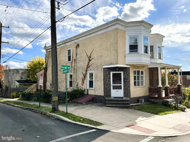 a view of a white house with large windows next to a road