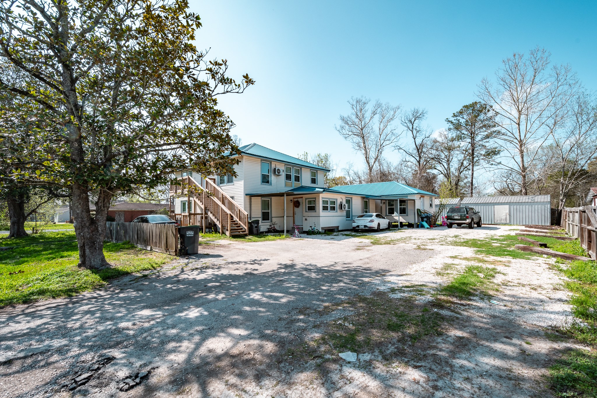 108 West Barrow Street Dayton, TX 77535 - Photo 1 of 18 a yellow house sitting in middle of a yard