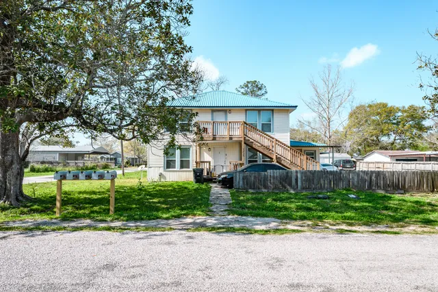 a front view of a house with a yard and potted plants