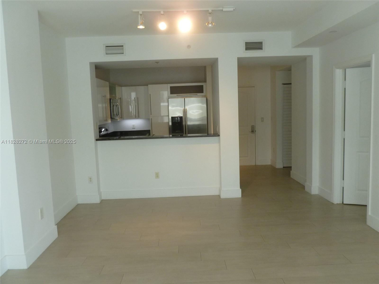 en empty room with wooden floor and windows