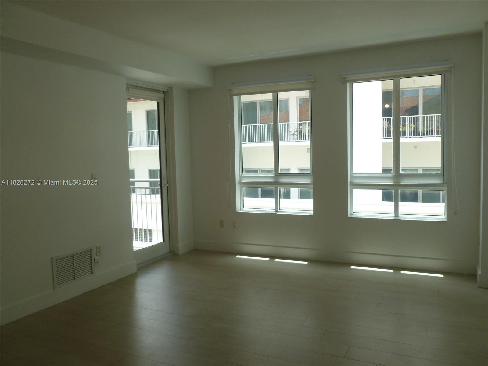 7350 Southwest 89th Street, Unit 808S Miami, FL 33156 - Photo 7 of 13 an empty room with wooden floor and windows