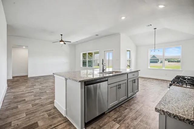 a large kitchen with kitchen island a sink stainless steel appliances and a counter space