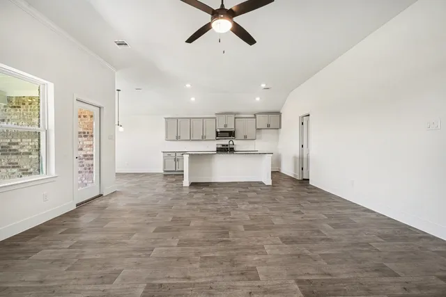 a large white kitchen with a stove a refrigerator and white cabinets