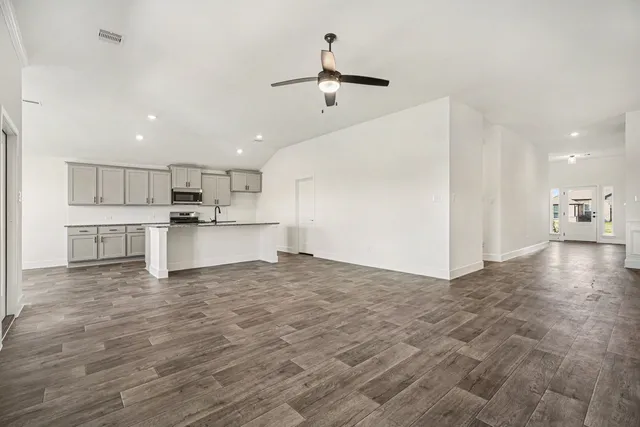 a view of a kitchen with a stove top oven a microwave and white cabinets