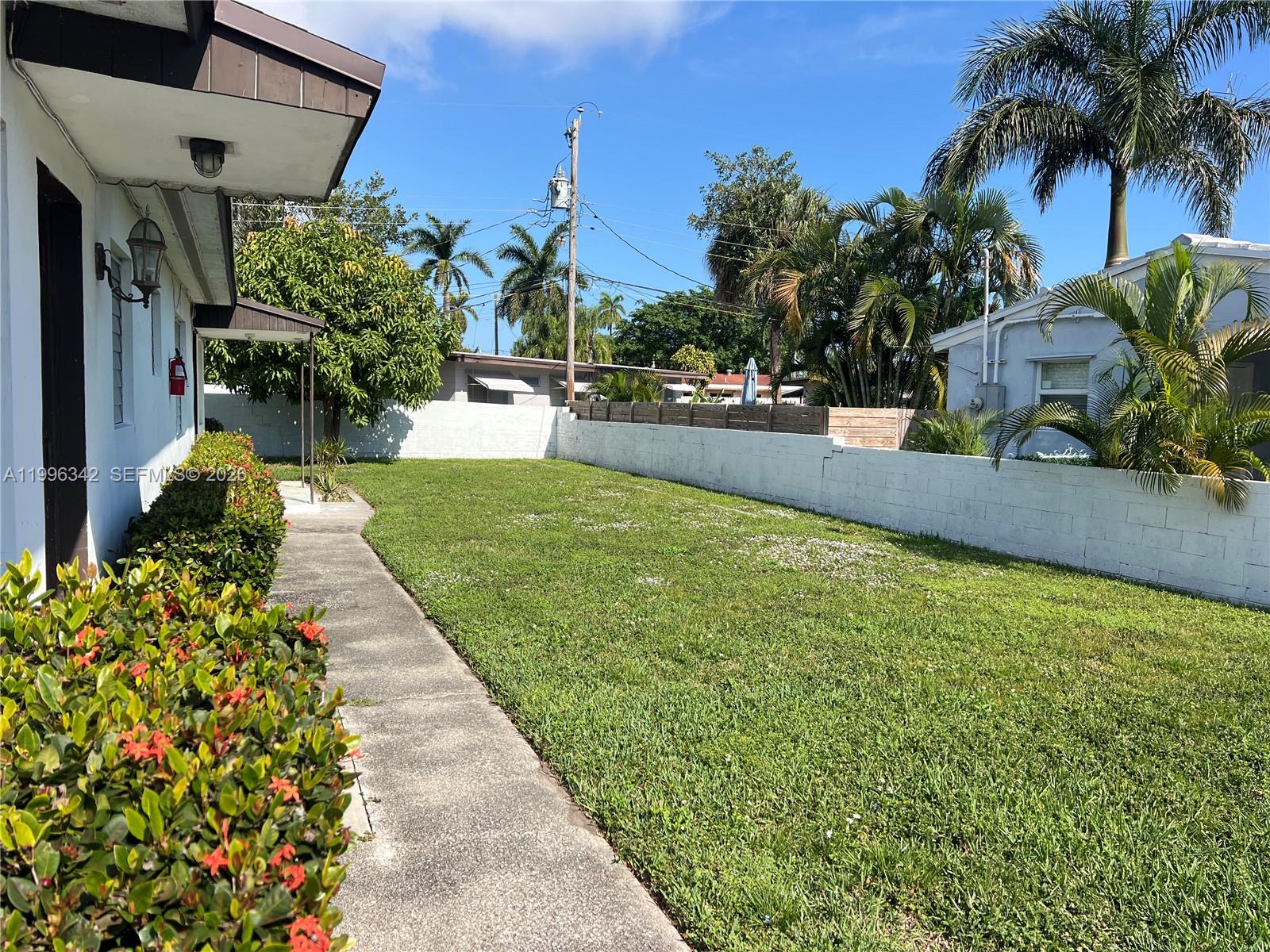 809 Northeast 2nd Street, Unit 2 Hallandale Beach, FL 33009 - Photo 2 of 8 a swimming pool with outdoor seating and plants