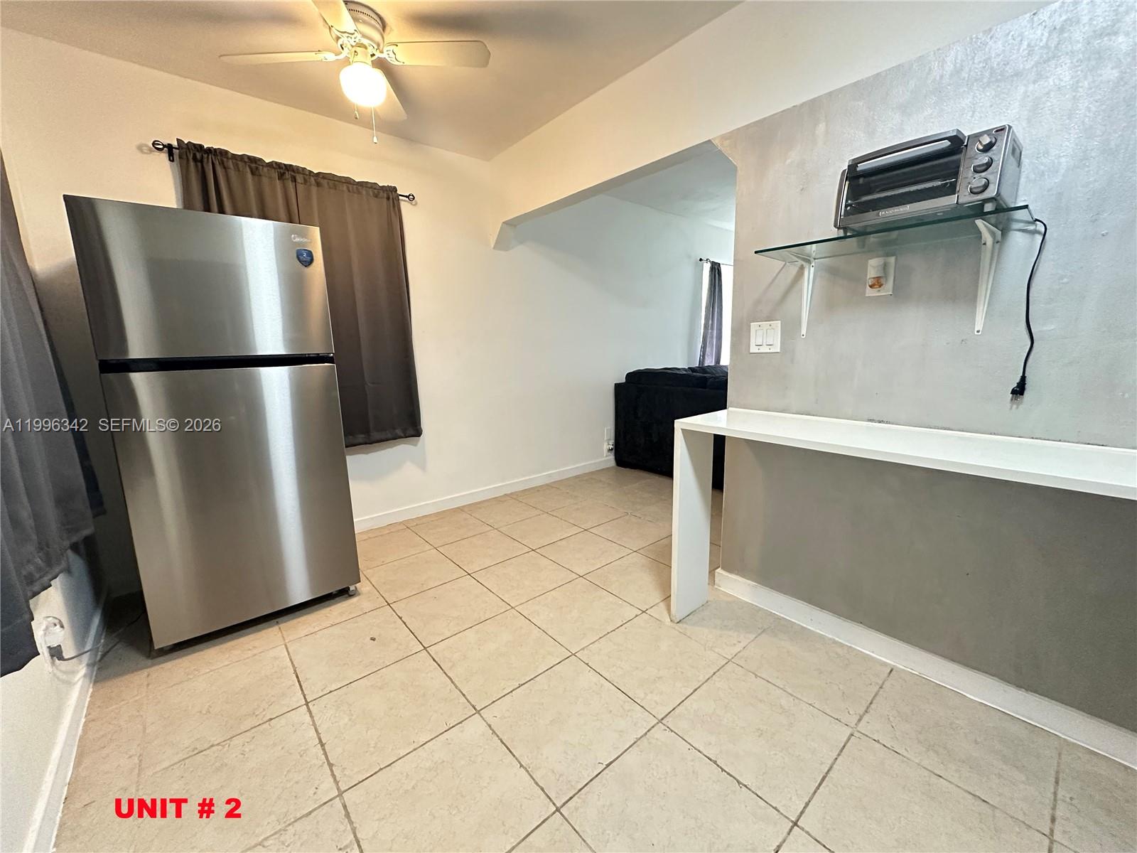 809 Northeast 2nd Street, Unit 2 Hallandale Beach, FL 33009 - Photo 4 of 8 a kitchen with stainless steel appliances a refrigerator and a stove top oven
