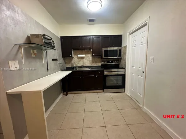 a large kitchen with a stove a refrigerator and a sink